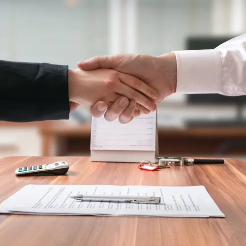 Two adults reach an agreement and shake hands.